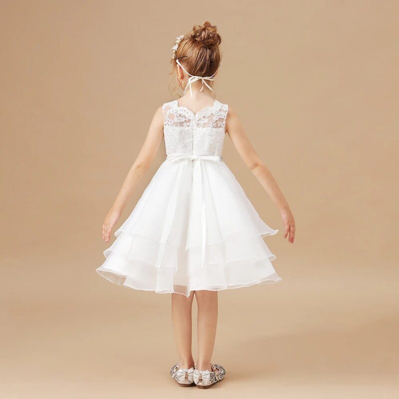 Back view of white A-line flower girl dress with lace bodice, sheer lace panel, satin ribbon sash and layered tulle skirt