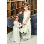 Girls Long Sleeve Lace Flower Girl Dress - ivory (3) Two girls wearing ivory lace flower girl dresses with long sleeves holding a flower basket indoors
