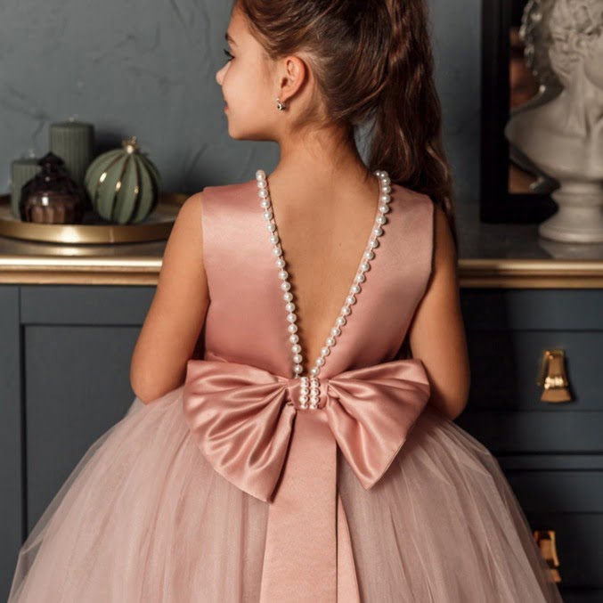 Back view of pink flower girl dress with pearl trimmed V back and oversized satin bow