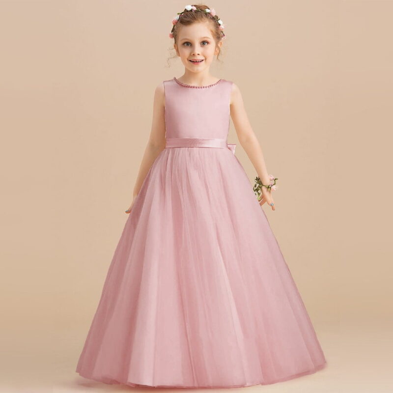Close up back detail of pink flower girl dress with pearl trim and oversized satin bow