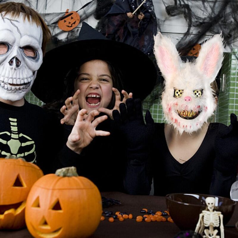 White furry horror rabbit mask worn during a Halloween costume party with pumpkins and spooky décor