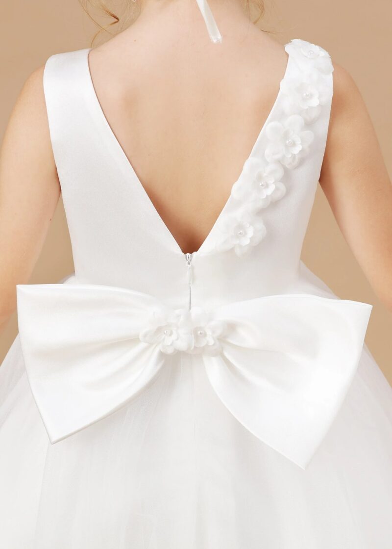 Back detail of girls white flower girl dress with V back, bow sash and floral appliqué, elegant high low wedding dress