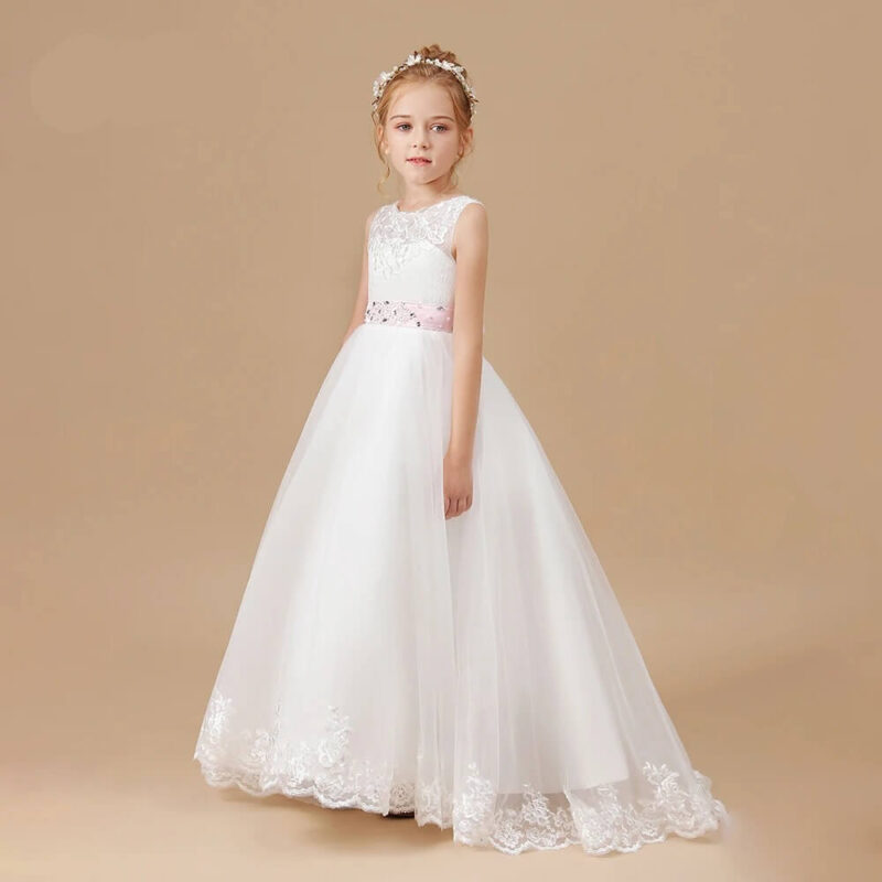 White girls flower girl dress with lace bodice, pink embellished waistband and full flowing tulle skirt with embroidered hem.
