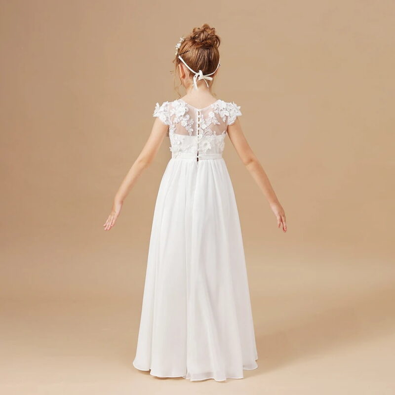 Back view of an ivory flower girl dress with floral lace appliqué bodice, sheer embroidered back, cap sleeves and flowing chiffon skirt for weddings and formal occasions.