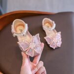 Girls pink sparkly shoes with butterfly bow design and pearl ankle strap suitable for parties and celebrations