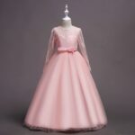 Front view of pink flower girl dress with lace bodice, long sleeves and elegant full length tulle skirt