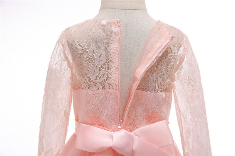 Close up back detail of pink flower girl dress showing lace bodice, zip fastening and satin waistband