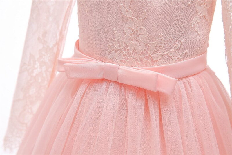 Close up front detail of pink flower girl dress with lace bodice, satin bow waistband and tulle skirt