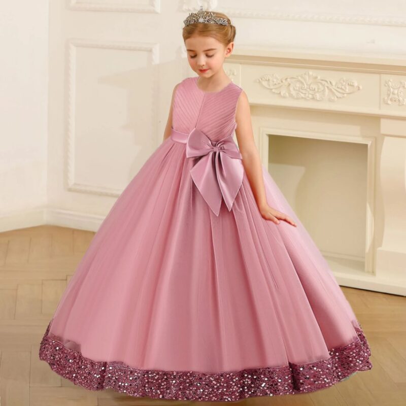 Girl wearing pink princess ball gown with sleeveless bodice, large satin waist bow, full tulle skirt and sparkling sequin hem.