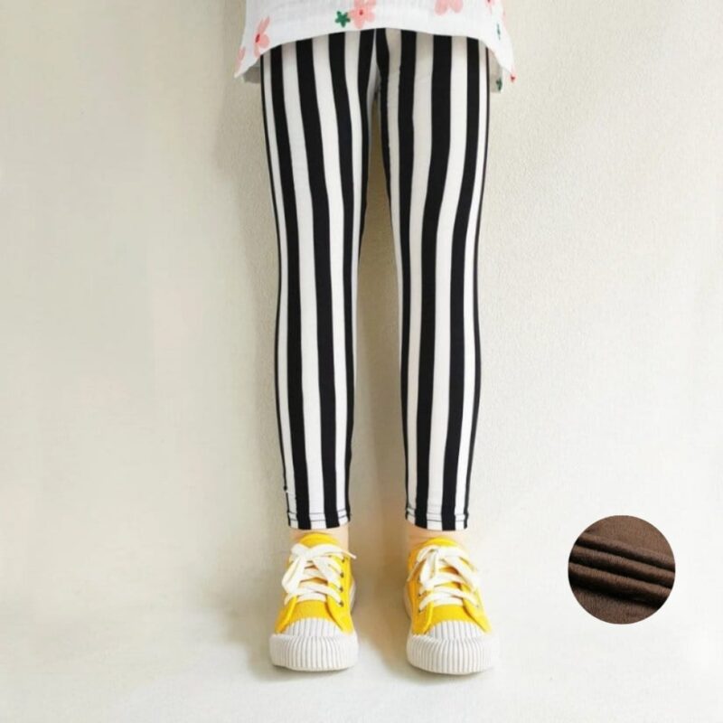 Girl wearing black and white striped winter leggings with a warm soft fleece lining.