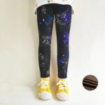 Girl wearing black galaxy print winter leggings with blue, purple and white stars and warm fleece lining.