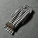 Folded black and white houndstooth print winter leggings for girls showing the soft brown fleece lining.