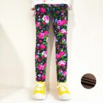 Girl wearing navy blue rose print winter leggings with pink flowers, green leaves and warm fleece lining.