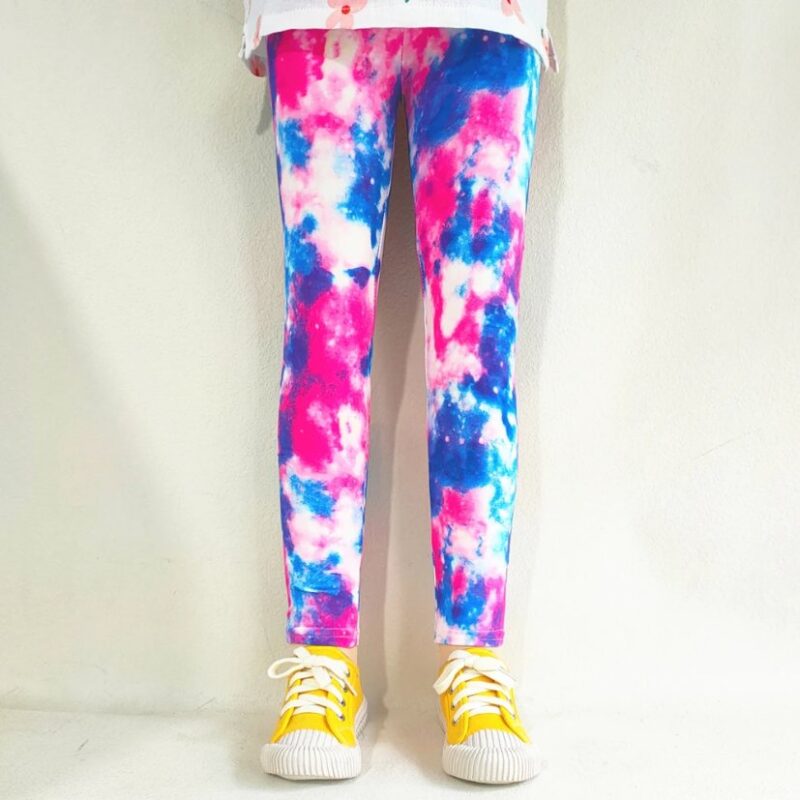 Girl wearing pink, blue and white tie-dye leggings with a colourful all-over print and slim fitted design.