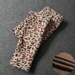 Folded cream leopard print fleece leggings for girls with brown and black spots, showing the soft fleece lining.