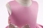 Close-up of sleeveless pink bodice and sequin bow detail on girls multi-layer princess party dress
