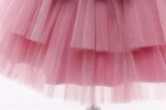 Close-up of pink girls princess dress showing soft layered tulle skirt fabric and full party dress design