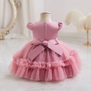 Back view of dark pink ruffled tulle princess dress for girls with large bow, zip fastening and full layered skirt