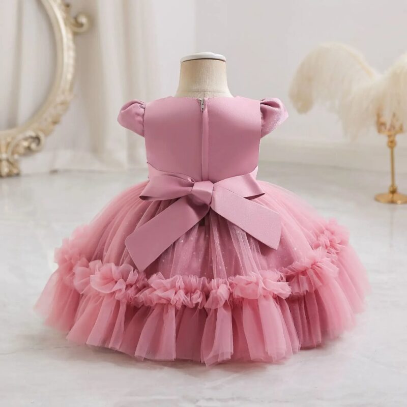 Back view of dark pink ruffled tulle princess dress for girls with large bow, zip fastening and full layered skirt