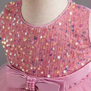Close-up of pink sequin bodice on girls party dress with satin waist bow and pearl embellishment