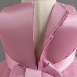 Close-up of back zip fastening and pink satin bodice on girls sequin and tulle party dress