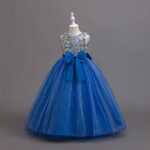 Side view of royal blue girls ball gown with gold sequin bodice, satin waist bow and glitter tulle skirt