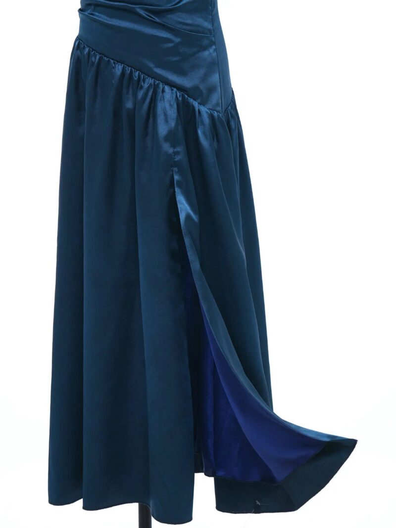 Close-up of the side split on a girls navy blue satin formal occasion dress with flowing full length skirt