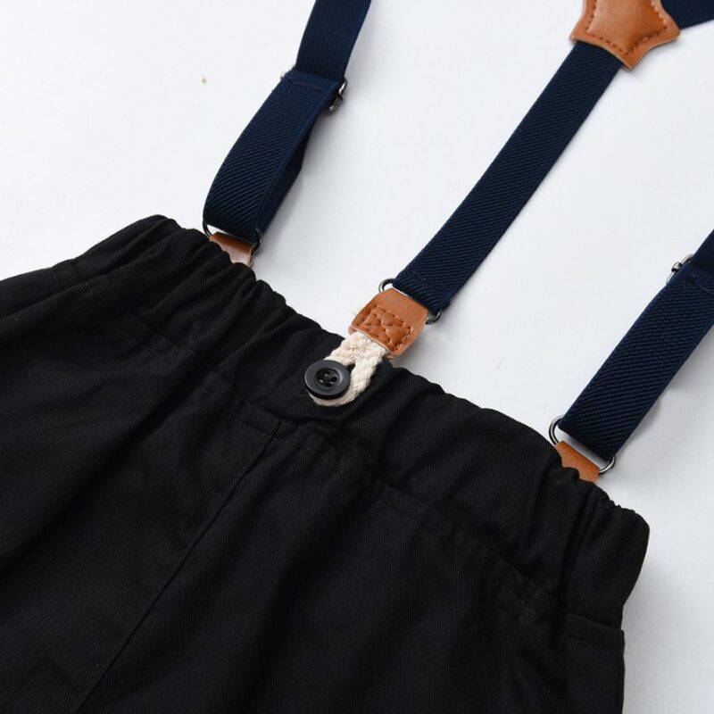 Close up of boys suspenders attachment on black formal trousers
