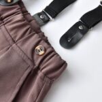 Close up of boys brown trousers with adjustable black suspenders and elasticated waistband