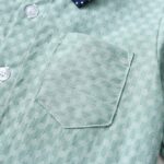 Close up of textured sage green boys shirt with stitched chest pocket