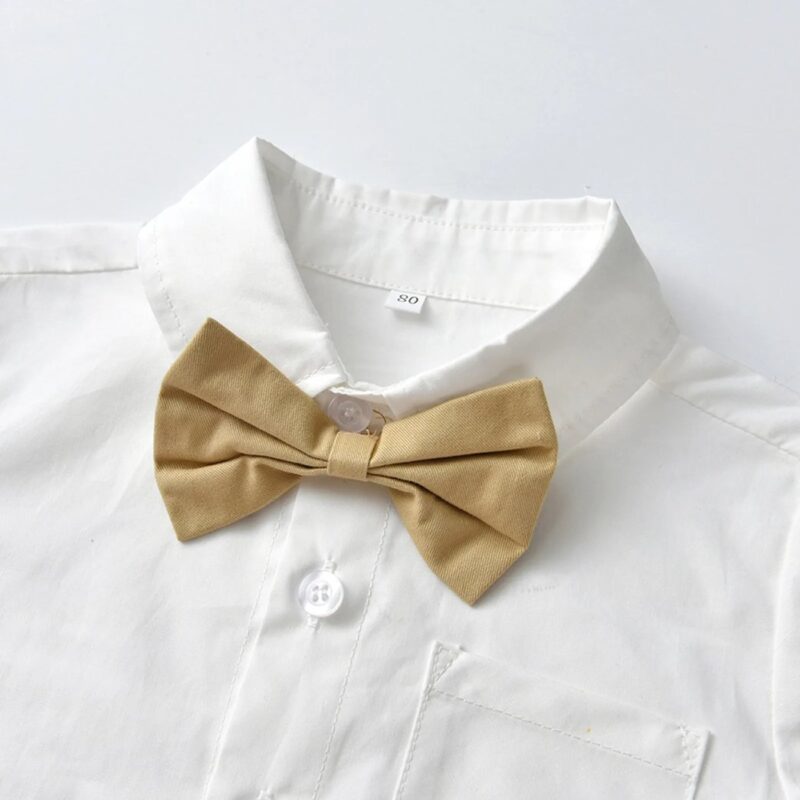 Close up of beige bow tie on boys white formal shirt with chest pocket