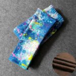 Folded blue graffiti splash fleece leggings for girls with colourful paint splatter print and warm fleece lining.
