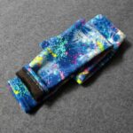Folded graffiti splash fleece leggings for girls showing the colourful blue paint effect print and soft brown fleece lining.