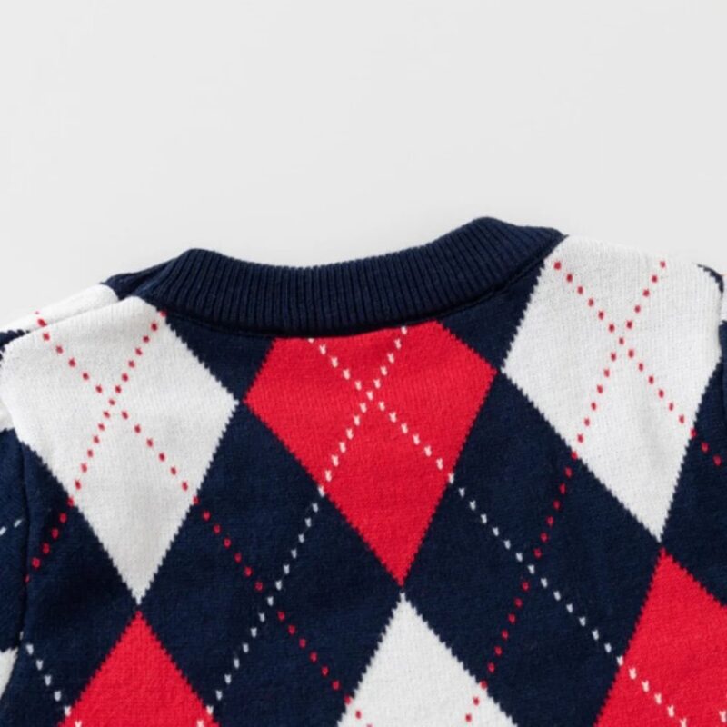 Close-up back view of kids argyle jumper showing ribbed navy neckline and knitted red, white and navy argyle pattern.