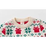 Close-up of kids Christmas tree and gift jumper showing cream ribbed crew neck, red presents and green snowflake pattern.