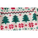 Close-up of kids Christmas jumper showing green Christmas trees, red snowflakes and traditional festive Fair Isle pattern.