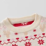 Close-up of cream kids Fair Isle Christmas jumper showing ribbed crew neck, reindeer, snowflakes and festive knitted pattern.