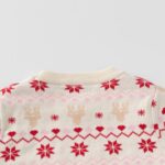 Close-up back view of cream kids Christmas jumper showing beige reindeer, red snowflakes and pink Fair Isle pattern.