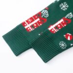 Close up of ribbed cuff on green knitted Christmas cardigan with festive gift pattern