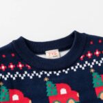 Kids Navy Christmas Truck Jumper (3) Close-up of kids navy Christmas jumper showing ribbed crew neck, red trucks carrying Christmas trees and Fair Isle pattern.