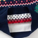 Kids Navy Christmas Truck Jumper (5) Inside view of kids navy Christmas jumper showing soft knitted fabric, ribbed hem and red, white and navy Fair Isle pattern.
