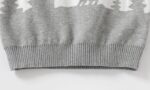 Close-up of kids polar bear Christmas jumper showing grey knitted hem, ribbed trim and winter woodland design.