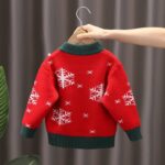Back view of red kids Christmas funnel neck jumper with white snowflake pattern and contrasting dark green ribbed trims.
