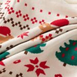 Kids Santa Bear Christmas Jumper (5) Close-up of soft knitted fabric on kids Santa bear Christmas jumper with green trees, red snowflakes and festive pattern.