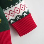 Kids Snowman Christmas Jumper (4) Close-up of kids Christmas jumper sleeve showing red ribbed cuff with green, white and red geometric festive knitted patterns.