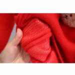 Kids Teddy Bear Christmas Jumper (5) Close-up of the inside of the red kids Christmas jumper showing the knitted fabric construction and soft texture.