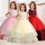 Girls sequin ball gowns in pink, white and red with sleeveless bodices, waist bows and full layered tulle skirts