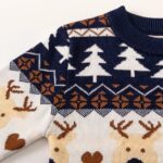 Close up sleeve of navy Christmas jumper with reindeer and Fair Isle knit pattern