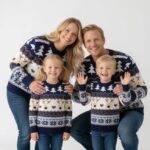 Family wearing matching navy reindeer Christmas jumpers for festive celebrations