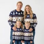 Family dressed in matching navy Christmas jumpers with festive reindeer design